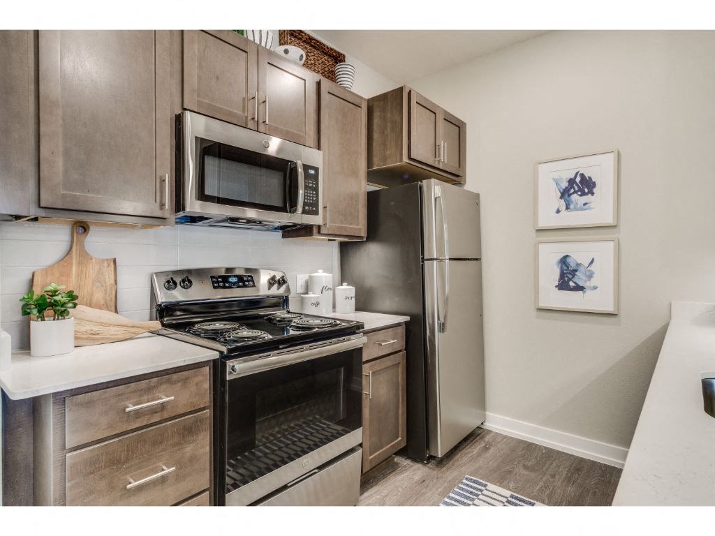 Kitchen with quartz countertops and stainless steel appliances at Montgomery Place Apartments, Illinois