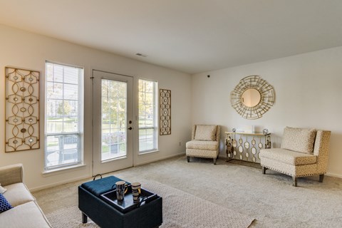 A living room with a black coffee table and two chairs.