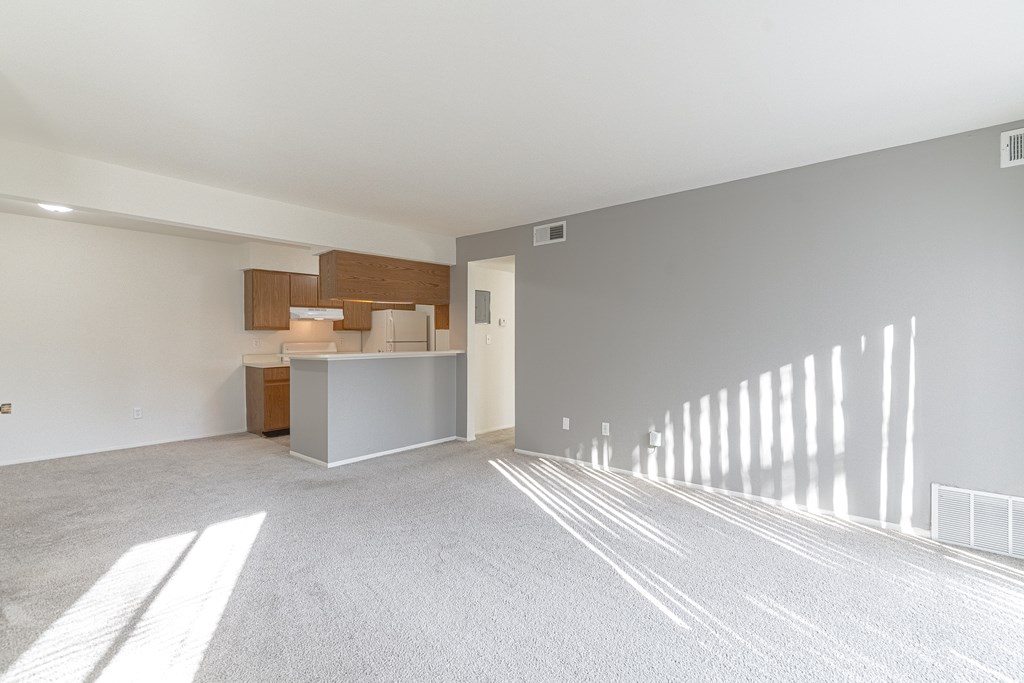 A spacious room with a reception desk and a white wall.