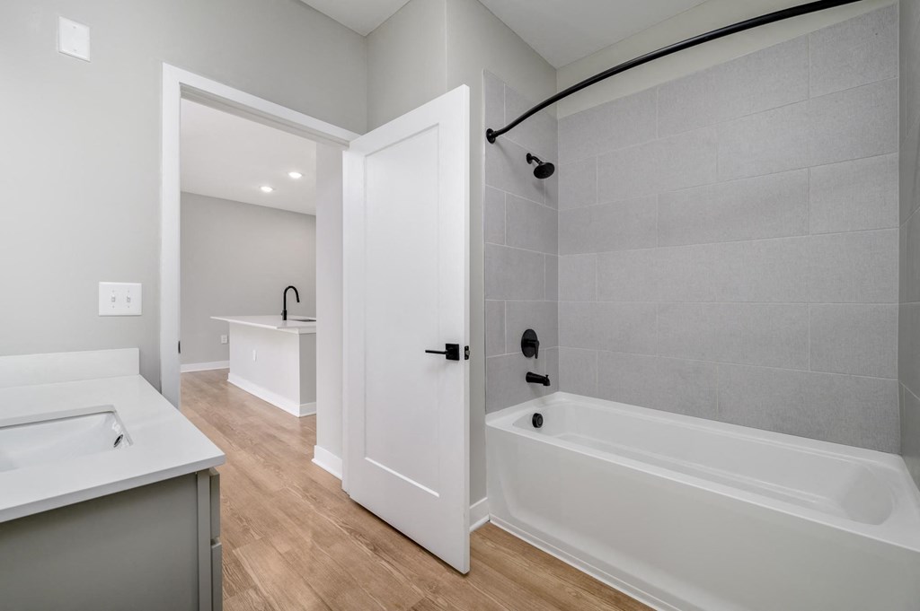 a white bathroom with a tub and a sink