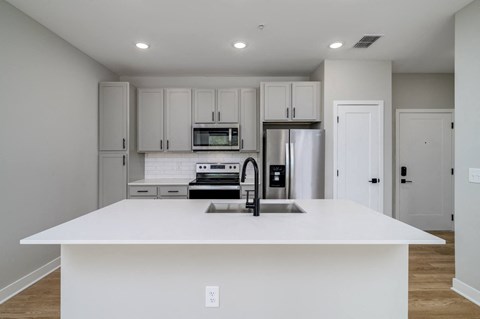 a white kitchen with a sink and a refrigerator