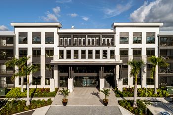 A modern building with a white facade and a central entrance at Ironwood Flats Apartments, Florida