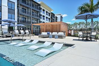 A pool area with sun loungers and a wooden structure at Ironwood Flats Apartments, Florida, 33511