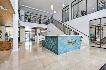 A reception area with a blue counter and a staircase at Ironwood Flats Apartments, Florida, 33511
