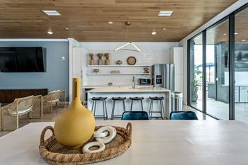 A modern kitchen with a wooden ceiling and a large yellow vase on a woven tray at Ironwood Flats Apartments, Brandon, FL