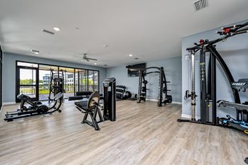 A spacious gym with a variety of equipment including a rowing machine, a stationary bike, and a treadmill at Ironwood Flats Apartments, Brandon, Florida