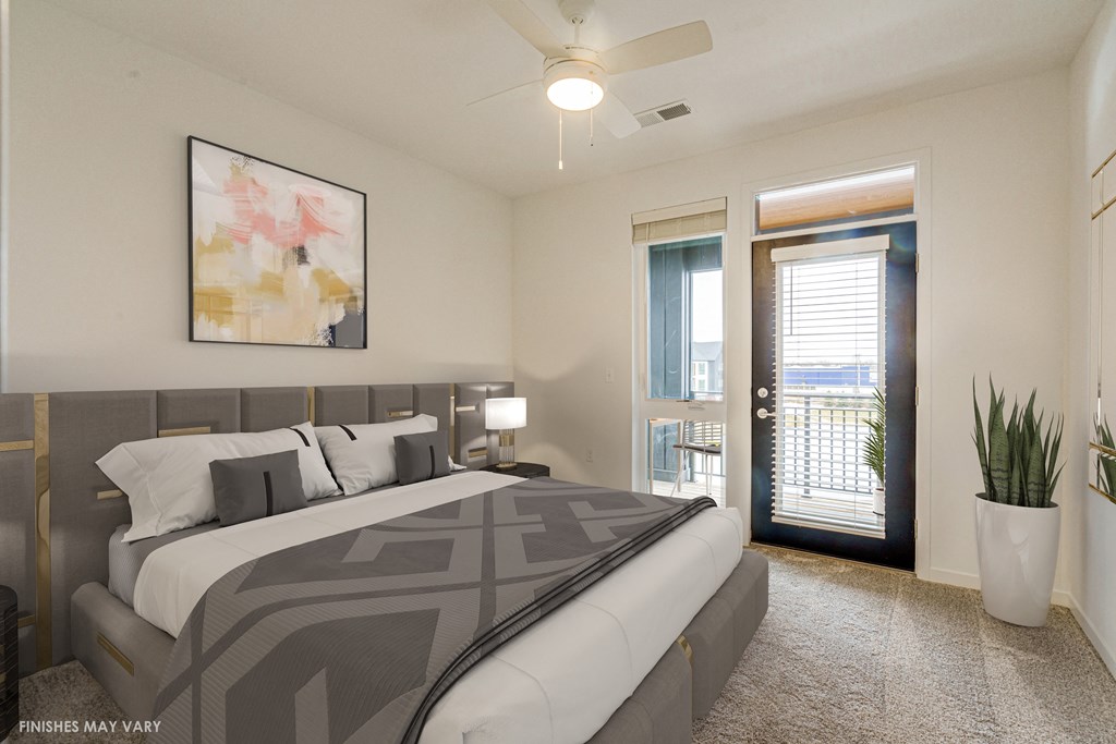 a bedroom with a large bed and a door leading to a balcony  at Uptown Square Apartments, Troy, Michigan