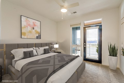 a bedroom with a large bed and a door leading to a balcony a bedroom with a large bed and a door leading to a balcony at Uptown Square Apartments, Troy, Michigan