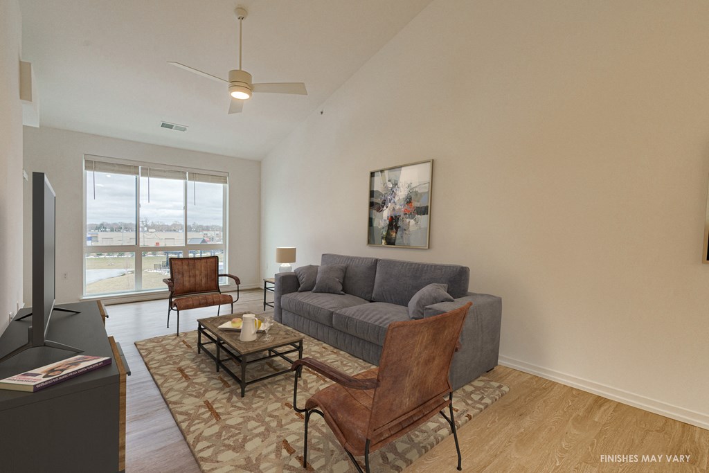 a living room with a gray couch and two brown chairs  at Uptown Square Apartments, Troy