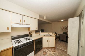 Kitchen with Gas Range and Dishwasher at Heatherwood Apartments in Grand Blanc, Michigan