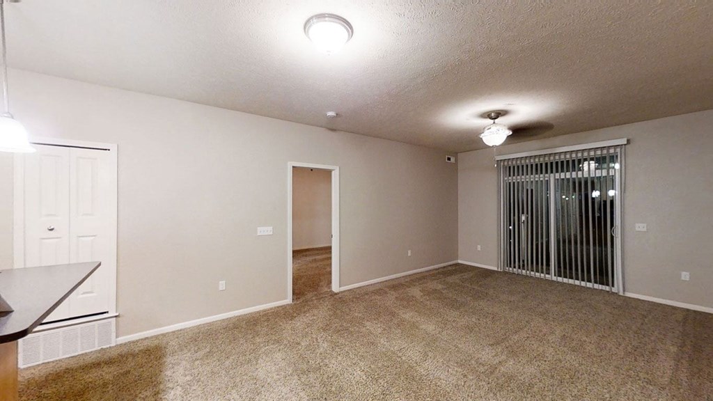 an empty living room with a door to a closet at Lynbrook Apartment Homes and Townhomes, Elkhorn