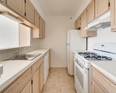 a kitchen with white appliances and wooden cabinets