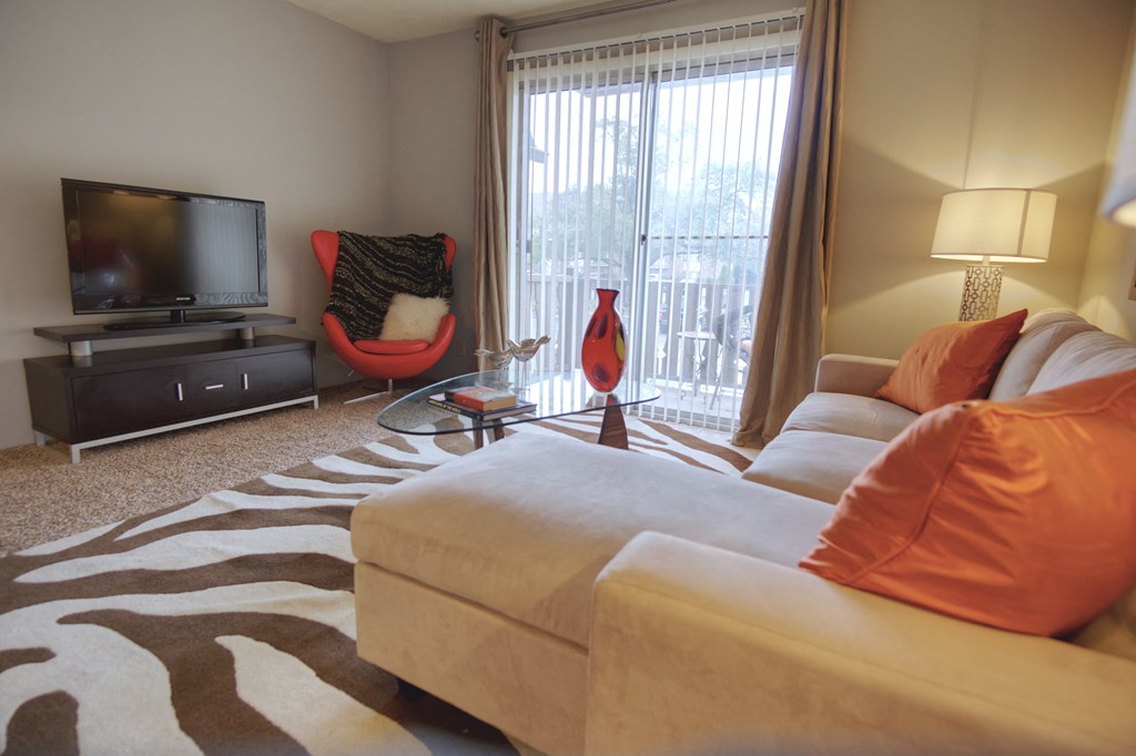 Living room with sofa and balcony at The Timbers Apartments, Evansville, IN, 47715