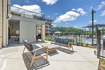 A patio with two chairs and a table at Luxe 360 on Centerpointe Apartments, Virginia