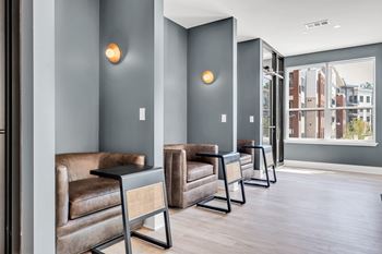 A row of brown leather chairs are lined up in a hallway at Luxe 360 on Centerpointe Apartments, Midlothian
