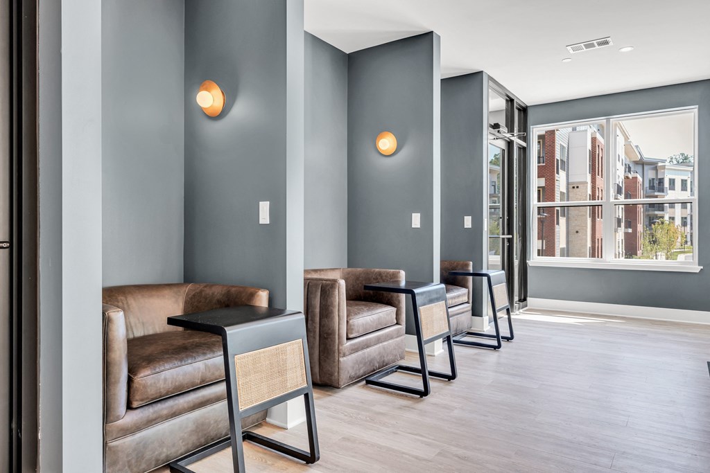 A row of brown leather chairs are lined up in a hallway at Luxe 360 on Centerpointe Apartments, Virginia, 23114