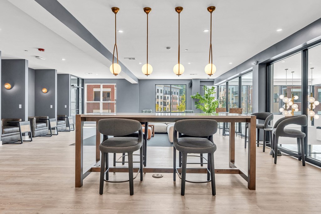 A modern dining area with a long table and chairs at Luxe 360 on Centerpointe Apartments, Midlothian, Virginia