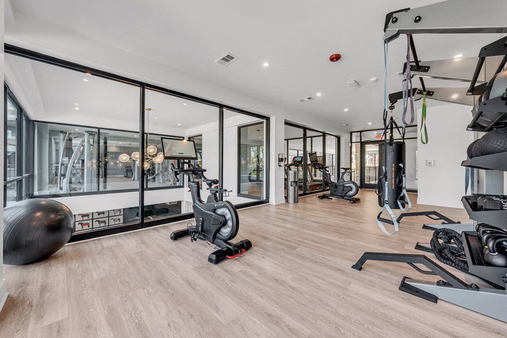 A gym with a variety of equipment including a stationary bike, a treadmill, and a rowing machine at Luxe 360 on Centerpointe Apartments, Midlothian