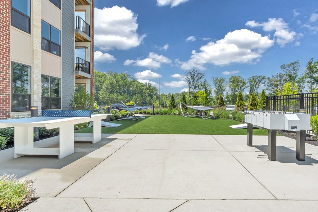 A sunny day at a residential complex with a white bench and a concrete path at Luxe 360 on Centerpointe Apartments, Midlothian, 23114