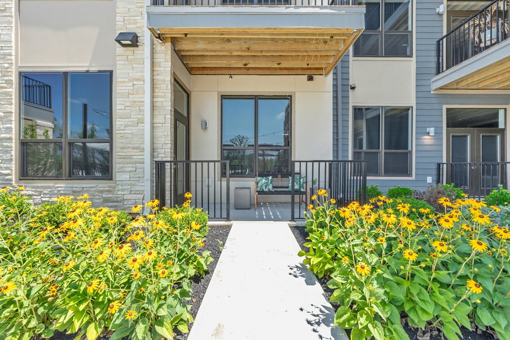 A building with a wooden entrance and a white walkway in front at Luxe 360 on Centerpointe Apartments, Midlothian, VA