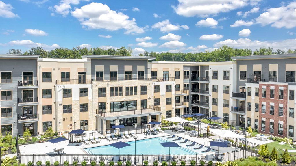 A large apartment complex with a pool in the middle. A large apartment complex with a pool in the middle at Luxe 360 on Centerpointe Apartments, Midlothian, VA