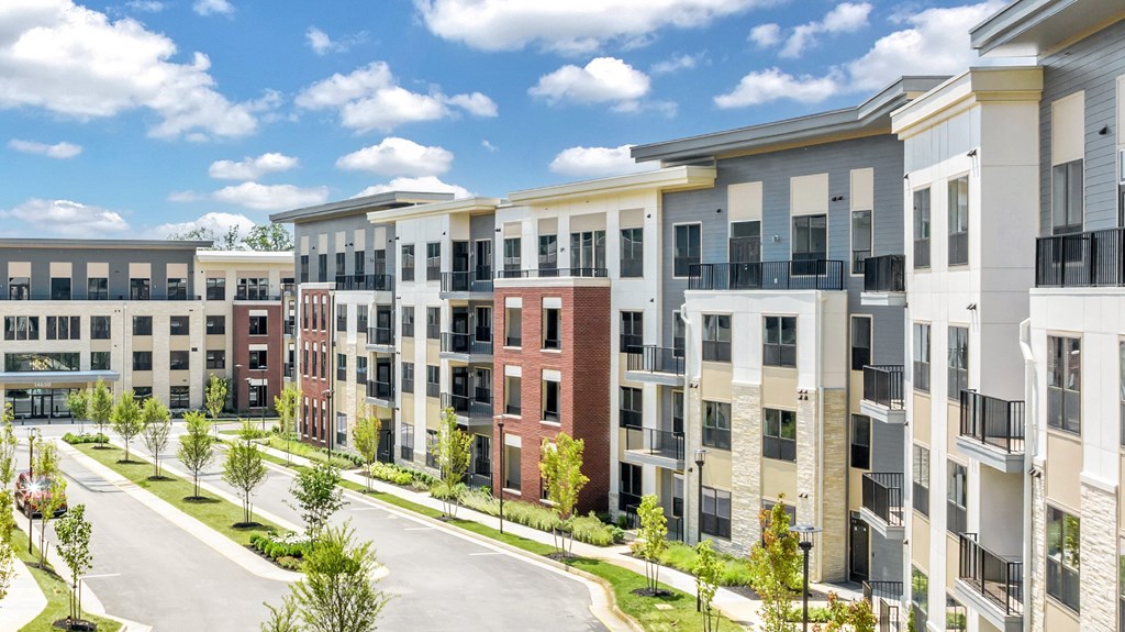 A row of modern apartment buildings with balconies and trees in front at Luxe 360 on Centerpointe Apartments, Virginia