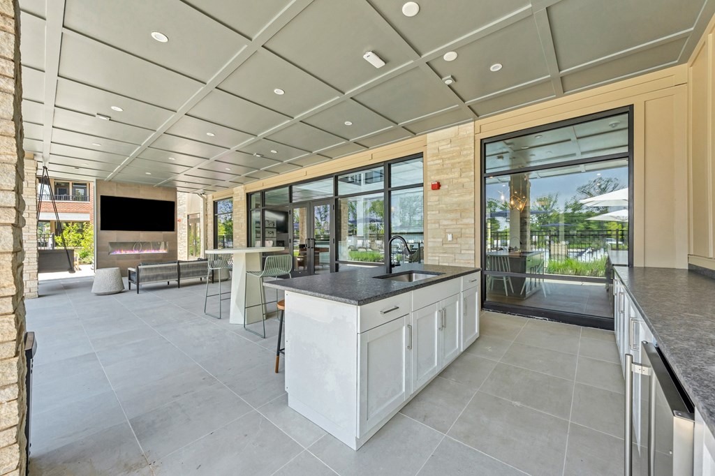 A modern kitchen with a large island and a view of the backyard at Luxe 360 on Centerpointe Apartments, Virginia, 23114