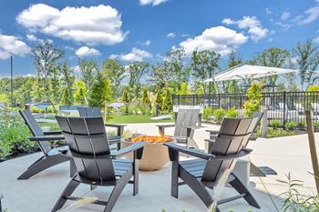 A patio with a table and chairs is set up for outdoor dining at Luxe 360 on Centerpointe Apartments, Midlothian, VA