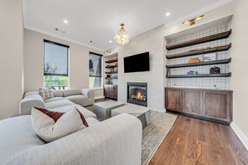 A modern living room with a grey couch and a fireplace at Luxe 360 on Centerpointe Apartments, Midlothian, VA