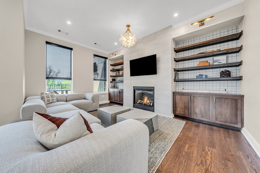 A modern living room with a grey couch and a fireplace at Luxe 360 on Centerpointe Apartments, Midlothian, VA, 23114