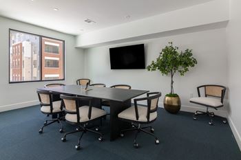 A conference room with a long table and chairs at Luxe 360 on Centerpointe Apartments, Midlothian, Virginia