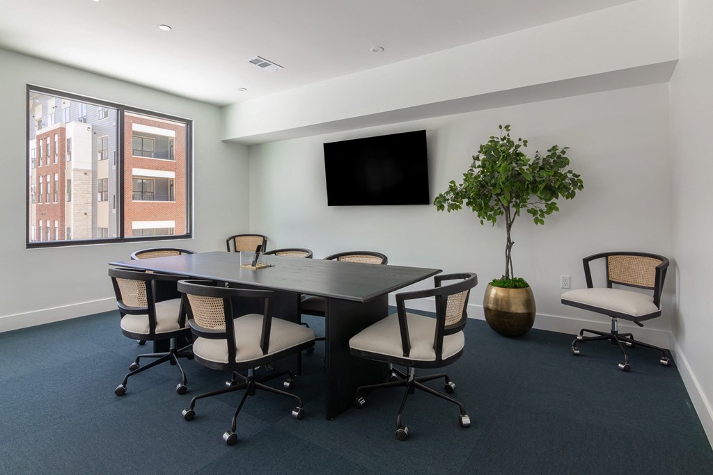 A conference room with a long table and chairs. at Luxe 360 on Centerpointe Apartments, Midlothian, VA