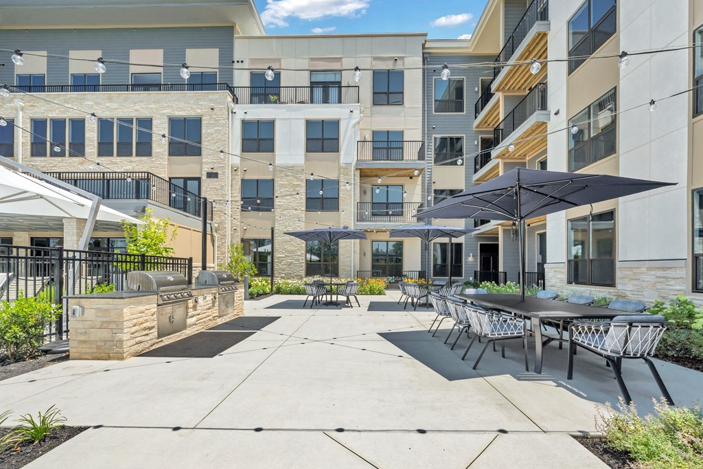 A sunny day at a modern apartment complex with a patio area at Luxe 360 on Centerpointe Apartments, Virginia