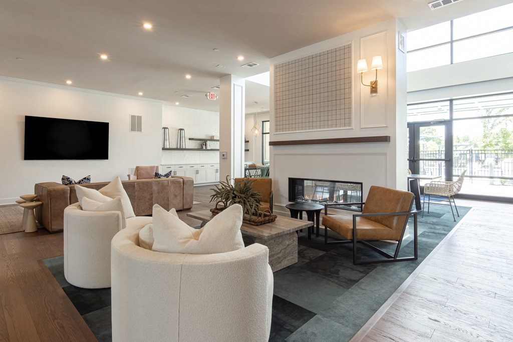 A modern living room with a flat screen TV mounted on the wall at Luxe 360 on Centerpointe Apartments, Virginia, 23114