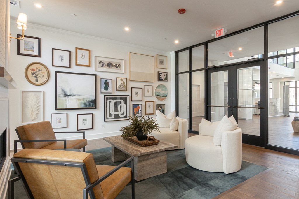 A living room with a brown chair and a plant on the coffee table at Luxe 360 on Centerpointe Apartments, Midlothian