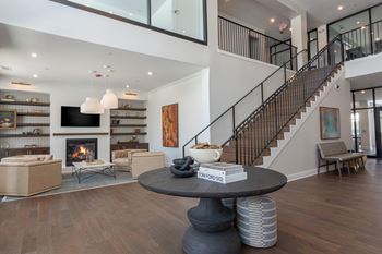 A living room with a fireplace and a staircase at Luxe 360 on Centerpointe Apartments, Midlothian, VA, 23114