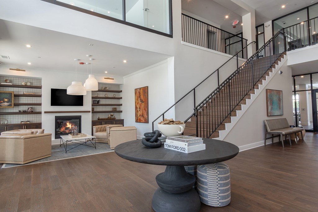 A living room with a fireplace and a staircase at Luxe 360 on Centerpointe Apartments, Midlothian, VA, 23114