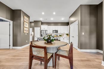 A modern kitchen with a dining table set for two at Luxe 360 on Centerpointe Apartments, Midlothian, 23114