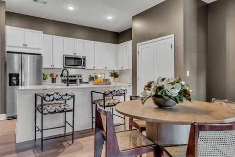A kitchen with a table and chairs.