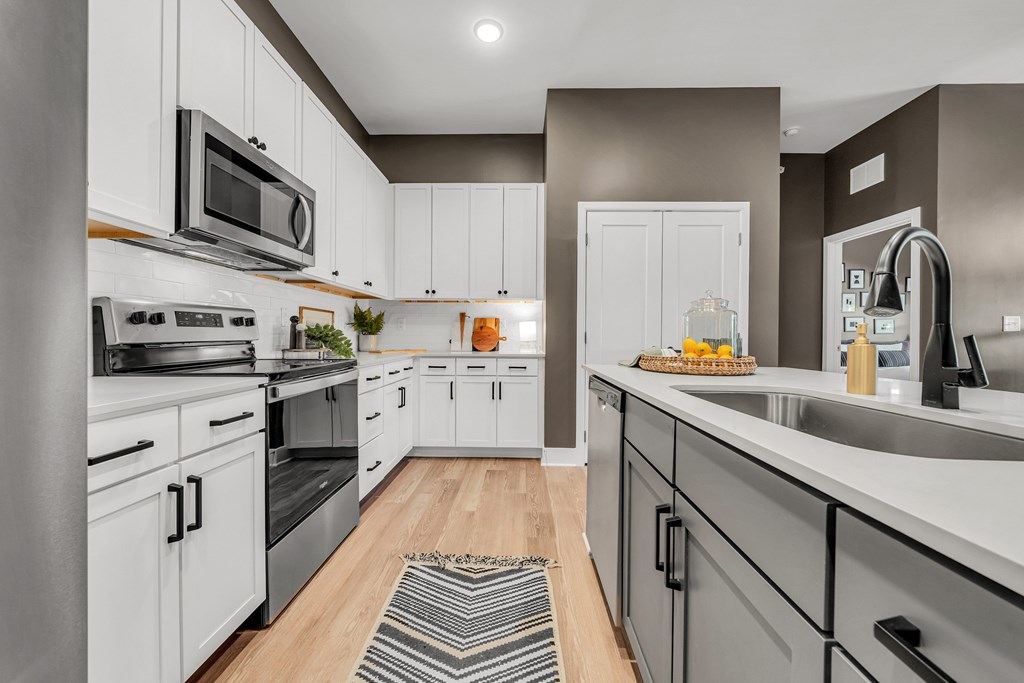 A modern kitchen with white cabinets and stainless steel appliances at Luxe 360 on Centerpointe Apartments, Midlothian, Virginia