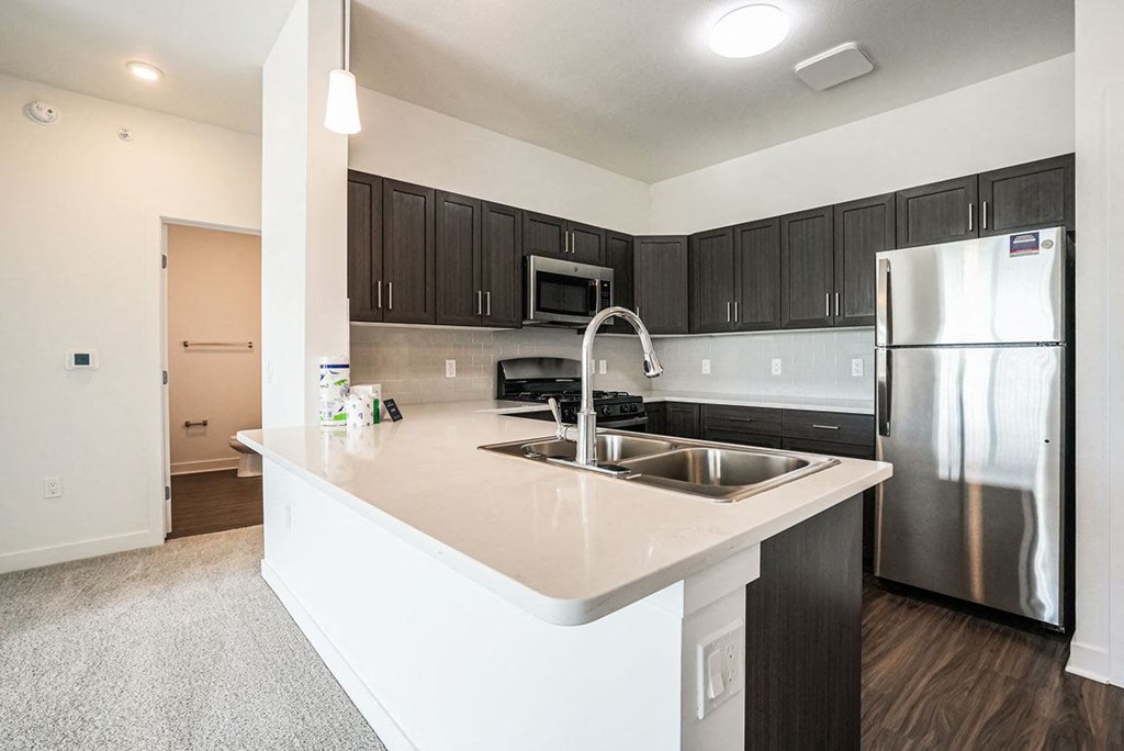 a kitchen with a large island and a stainless steel refrigerator at Meadowbrooke Apartment Homes, Michigan, 49512