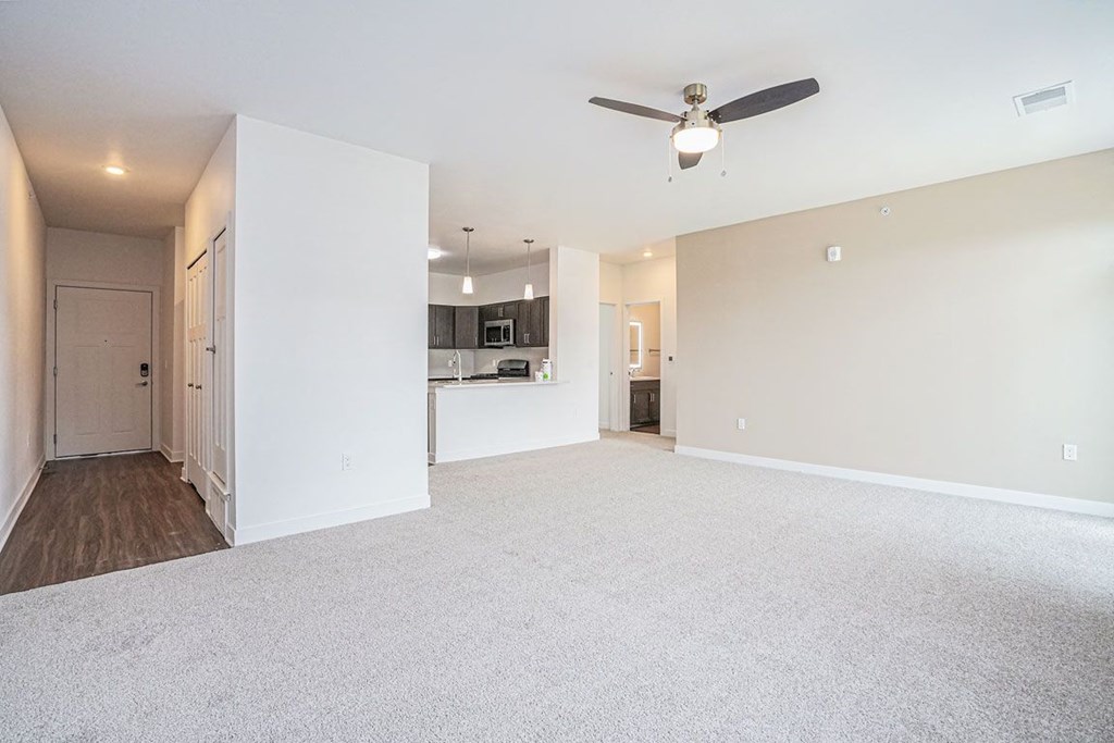 an empty living room with a ceiling fan at Meadowbrooke Apartment Homes, Michigan