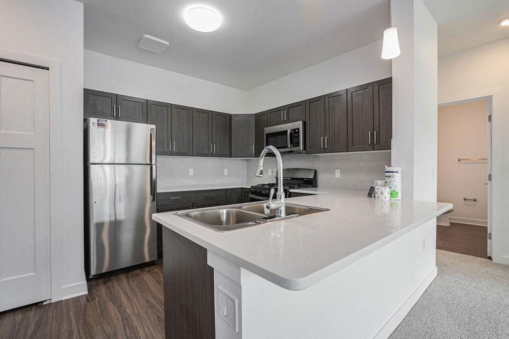 a kitchen with a large island and a stainless steel refrigerator at Meadowbrooke Apartment Homes, Grand Rapids, MI