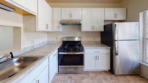 a kitchen with stainless steel appliances and white cabinets