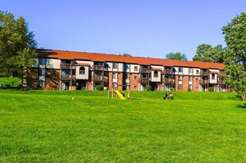 a large grassy field with a playground at Mount Royal Townhomes, Kalamazoo, MI, 49009