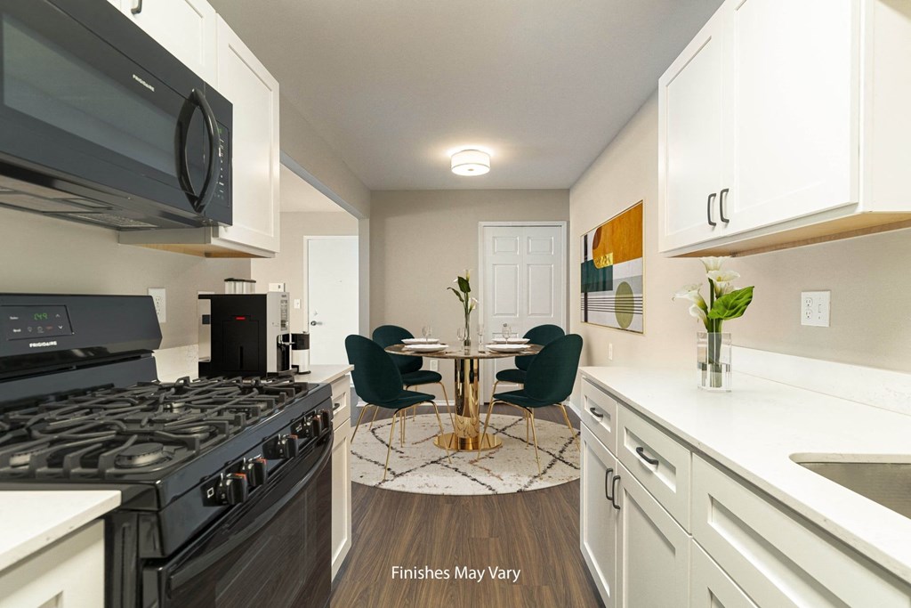 a kitchen with white cabinets and a black stove top oven at Cordoba Apartments, Farmington Hills, 48334
