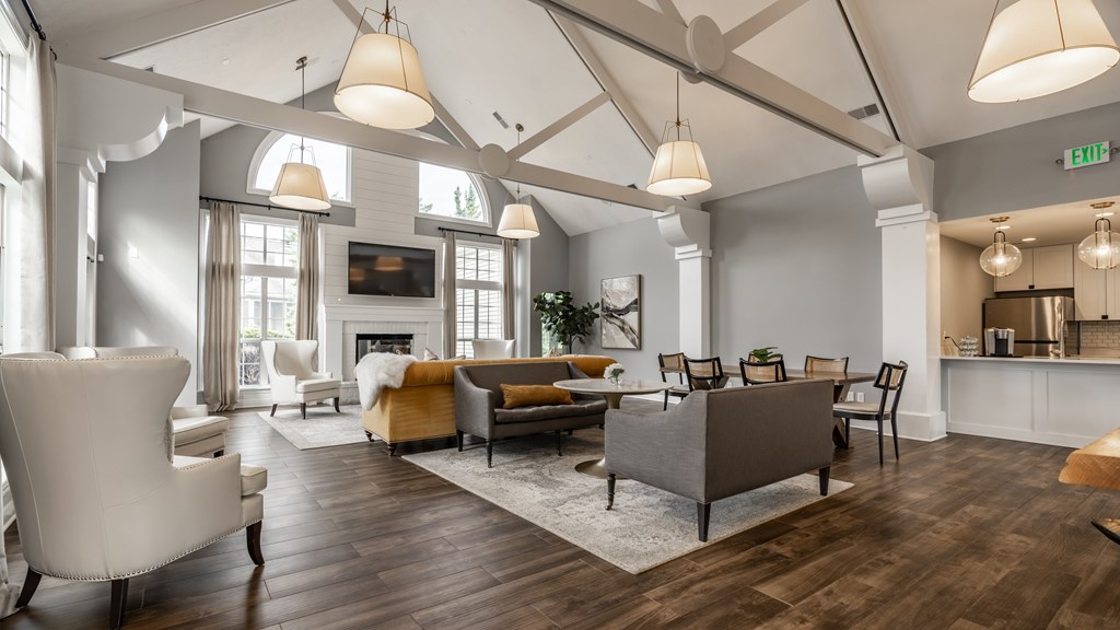 A living room with a white chair and a grey sofa at Mallard Bay Apartments, Crown Point, Indiana