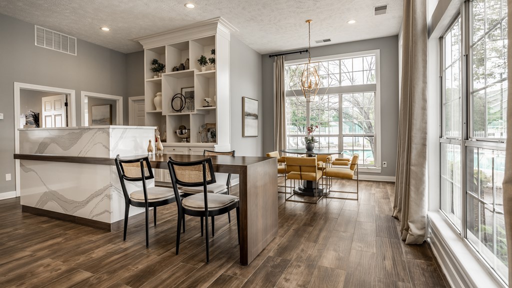 A kitchen with a white counter and a dining table with chairs at Mallard Bay Apartments, Crown Point, Indiana