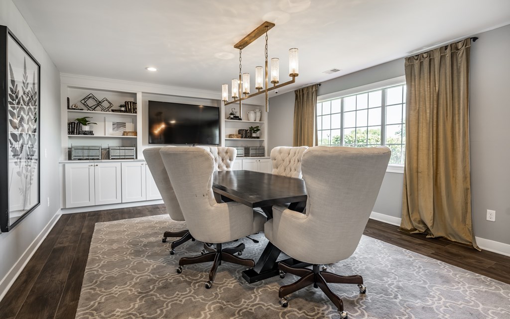 A large, well-lit living room with a wooden table and chairs at Mallard Bay Apartments, Crown Point, Indiana