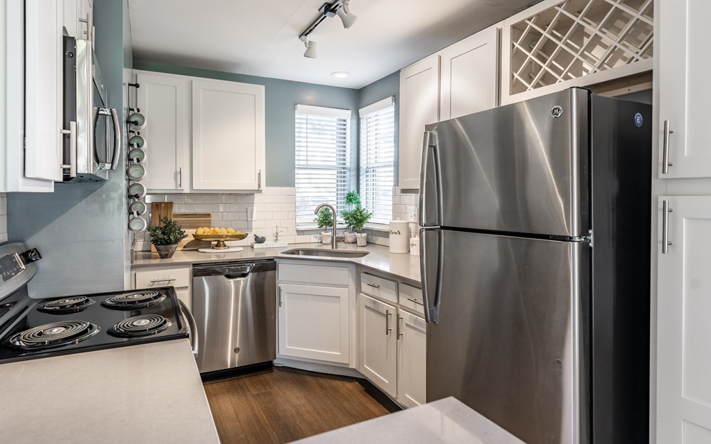 A modern kitchen with a stainless steel refrigerator and white cabinets at Mallard Bay Apartments, Crown Point, Indiana